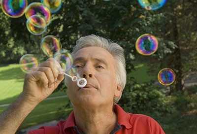 older man with respiratory disease blowing bubbles