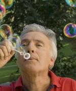 older man with respiratory disease blowing bubbles